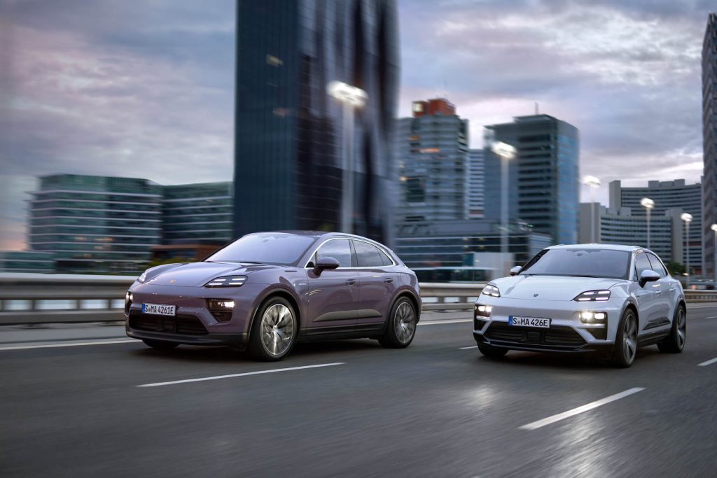 Two 2025 Porsche Macan EVs driving next to each other in city