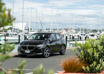 Black BMW 225e parked showing front quarter angle in a marina