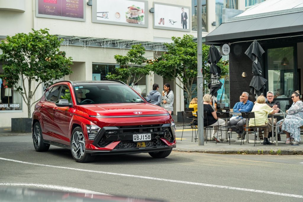 2023 Hyundai Kona driving next to a cafe