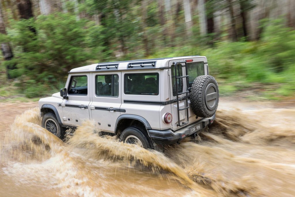 Ineos Grenadier splashing quickly through a muddy river