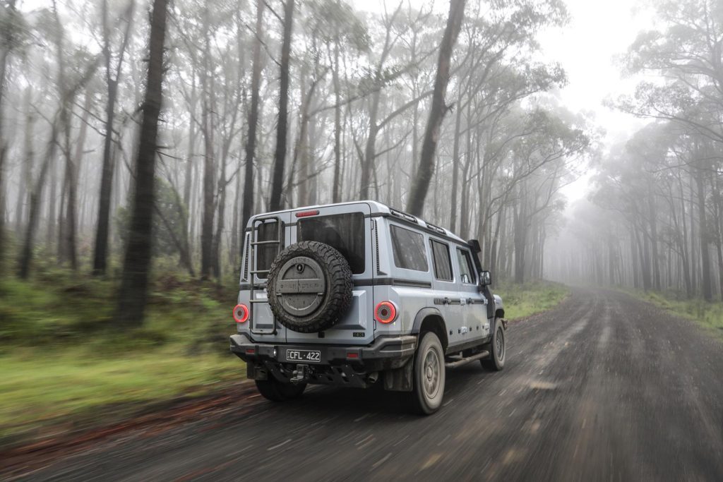 Ineos Grenadier rear quarter moving shot, in a forest