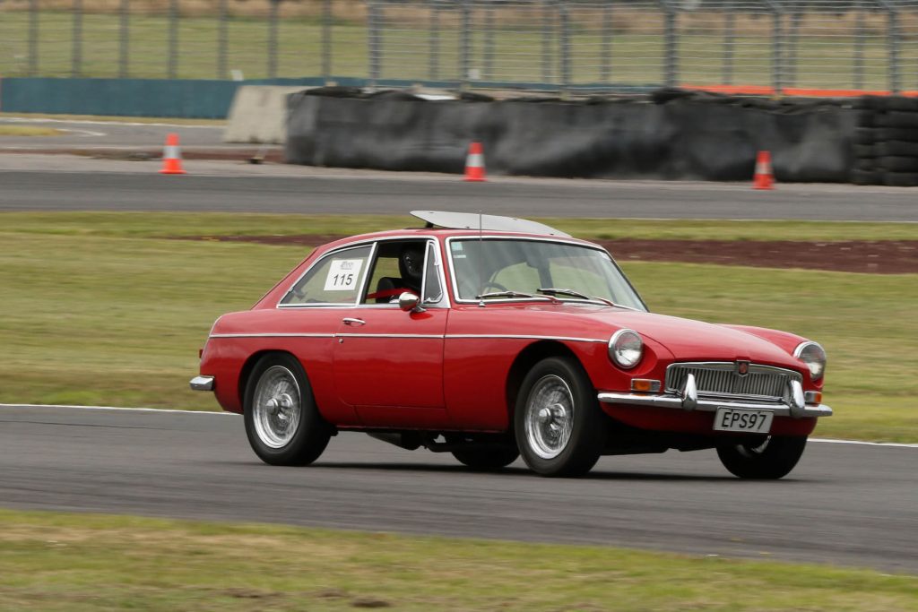 MG B GT driving around corner on race track