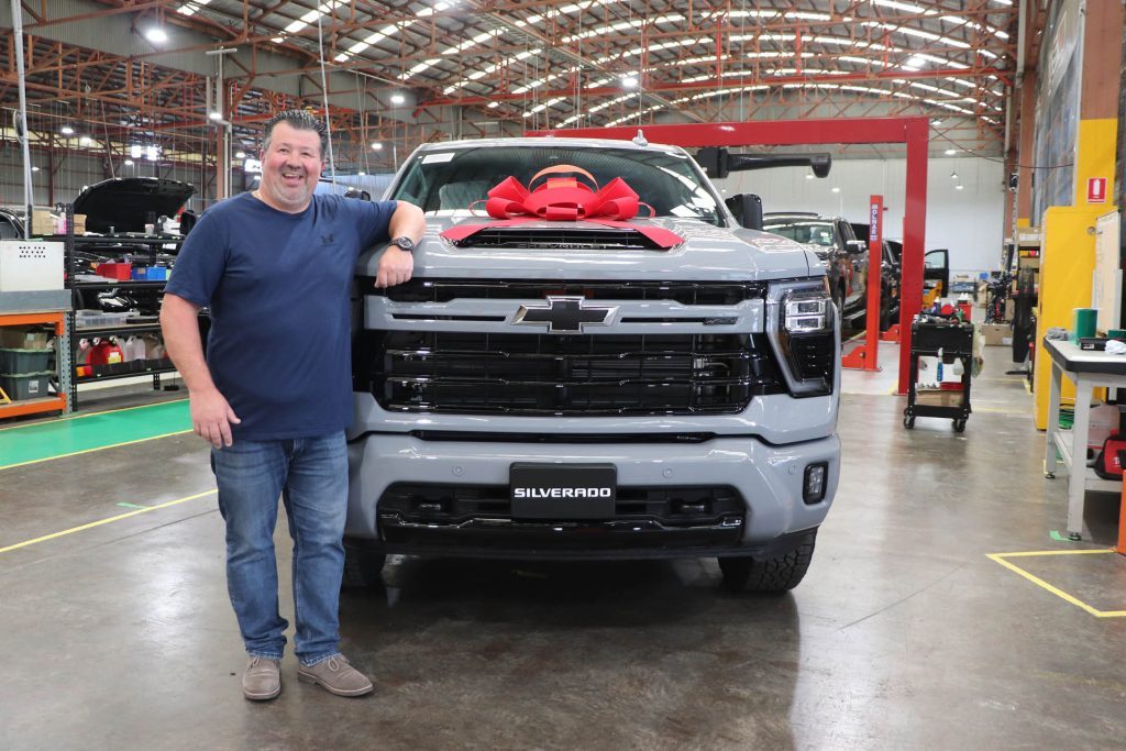 Owner standing next to 10,000th remanufactured Chevrolet Silverado
