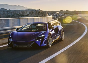 2025 McLaren Artura Spider driving on road at sunset