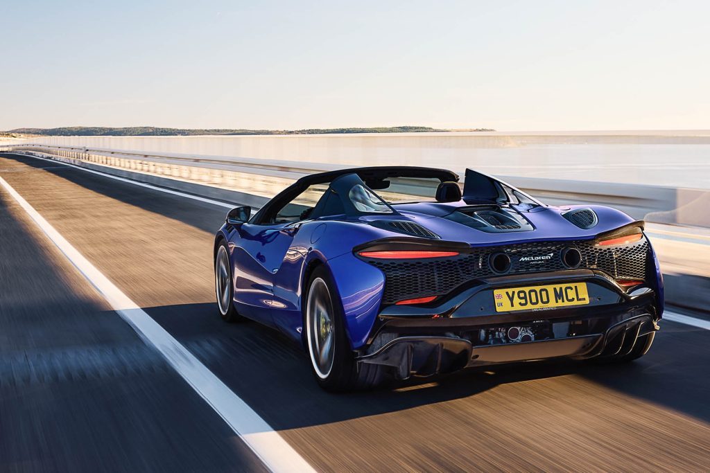 2025 McLaren Artura Spider driving on road at sunset