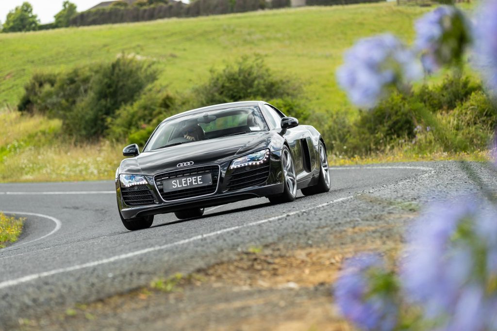 Audi R8 in black takes a corner at pace