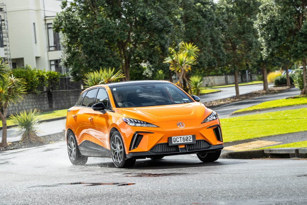 MG MG4 in orange, taking a corner on a wet day