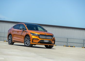 Skoda Enyaq 80 Coupe in orange, parked on a rooftop in the sun