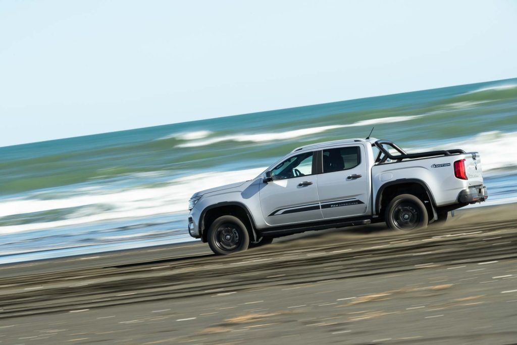 VW Amarok ute in a panning shot, with a beach backdrop