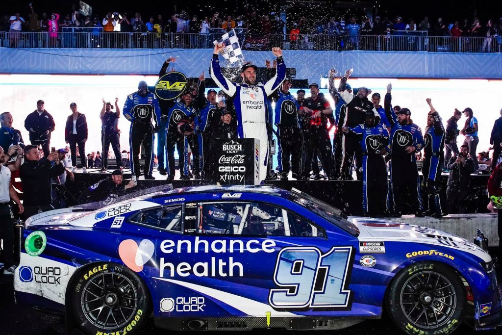 Shane van Gisbergen standing on NASCAR to celebrate Chicago Street Race win in 2023