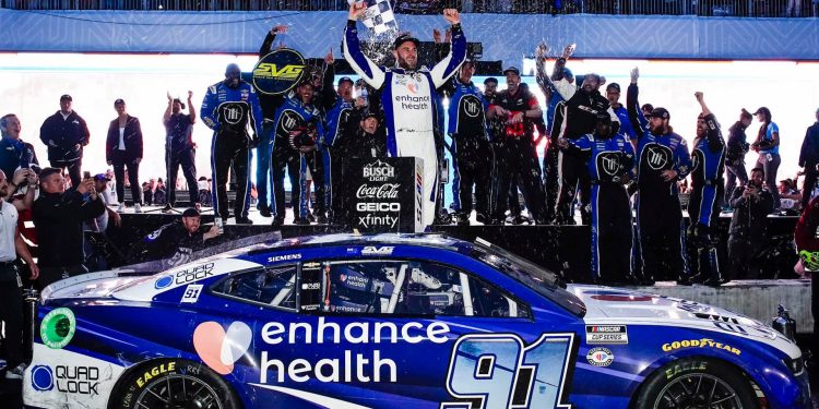 Shane van Gisbergen standing on NASCAR to celebrate Chicago Street Race win in 2023