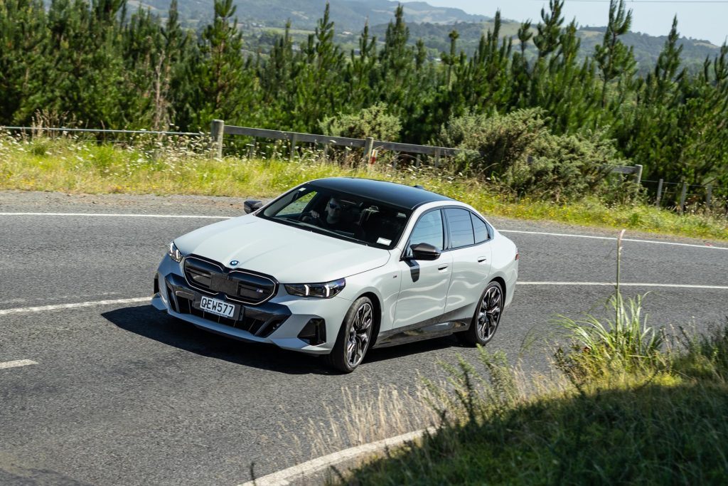 front view of the BMW i5 M60 taking a corner at pace, high angle