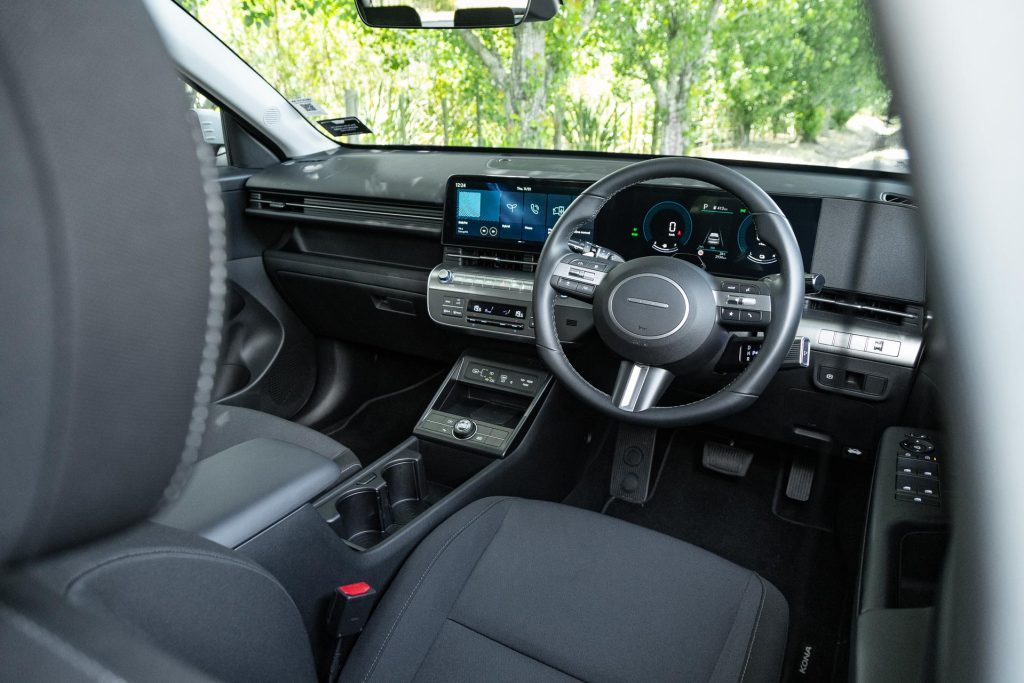 Interior front wide shot, showing infotainment screen and steering wheel