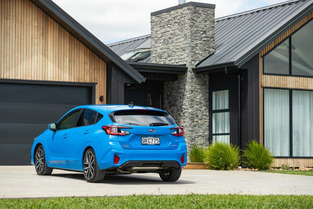 2024 Subaru Impreza rear view, parked in front of a nice house