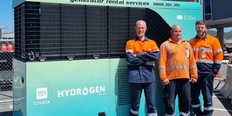 Men standing next to hydrogen generator
