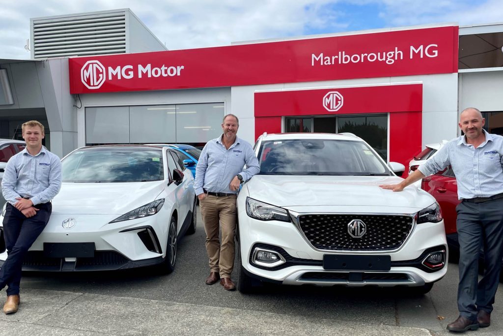 Dealer Principal, Simon Wakelin and Sales Consultants, Sky Boskett-Barnes and Matthew Grigg standing with MG cars at Marlborough dealership