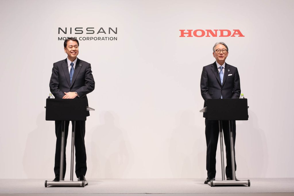 Nissan and Honda CEOs standing at podiums