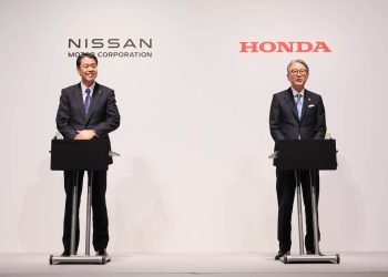 Nissan and Honda CEOs standing at podiums