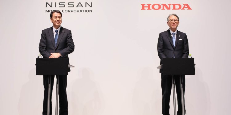 Nissan and Honda CEOs standing at podiums