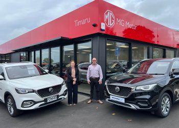 Keryn Pow, Business Manager and Sales Consultant, Pierre Guinan standing with MG cars at Timaru dealership