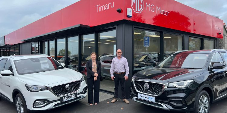 Keryn Pow, Business Manager and Sales Consultant, Pierre Guinan standing with MG cars at Timaru dealership