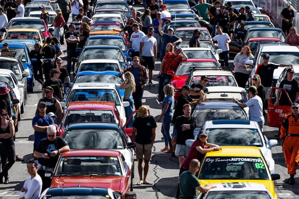Toyota owners standing with cars on race track grid