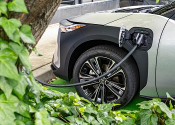 2024 Toyota bZ4X charging next to tree