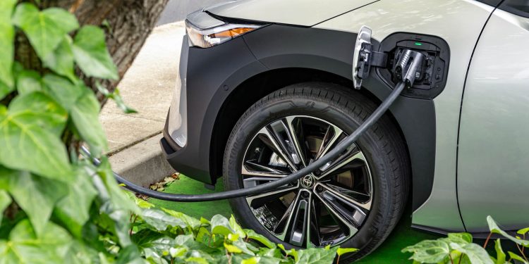 2024 Toyota bZ4X charging next to tree