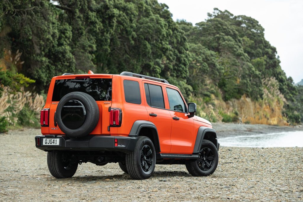 Orange GWM Tank 300 Lux Hybrid parked on a gravel beach