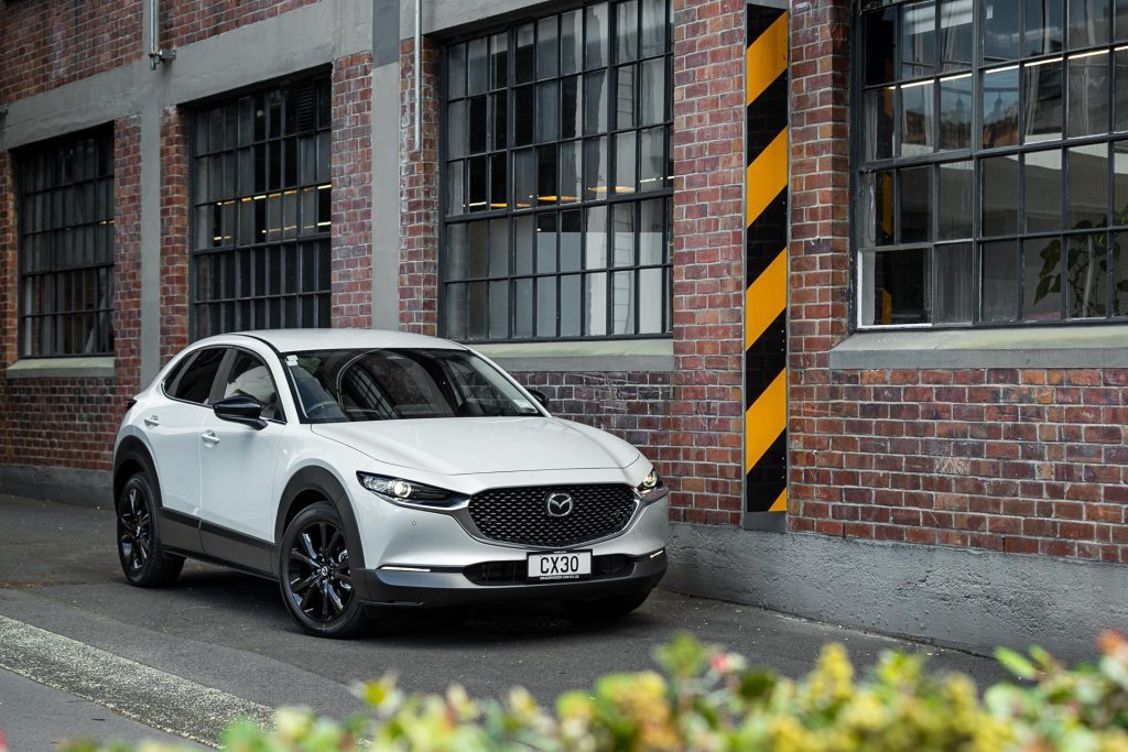 Mazda CX-30 SP25 in white, parked next to a brick wall