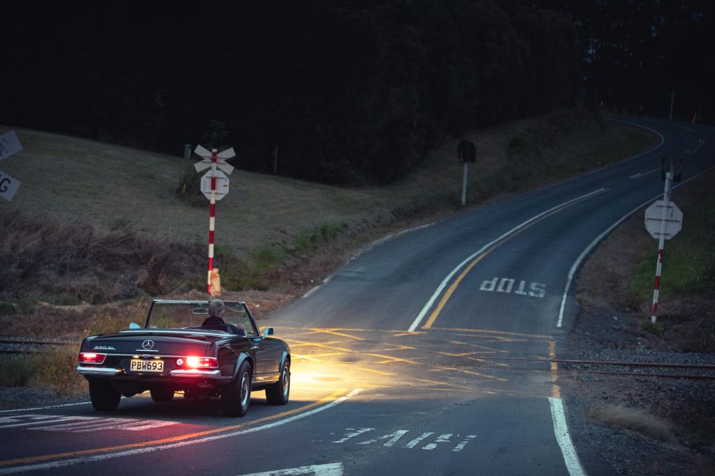 Mercedes-Benz 230 SL Pagoda at night, crossing railway tracks