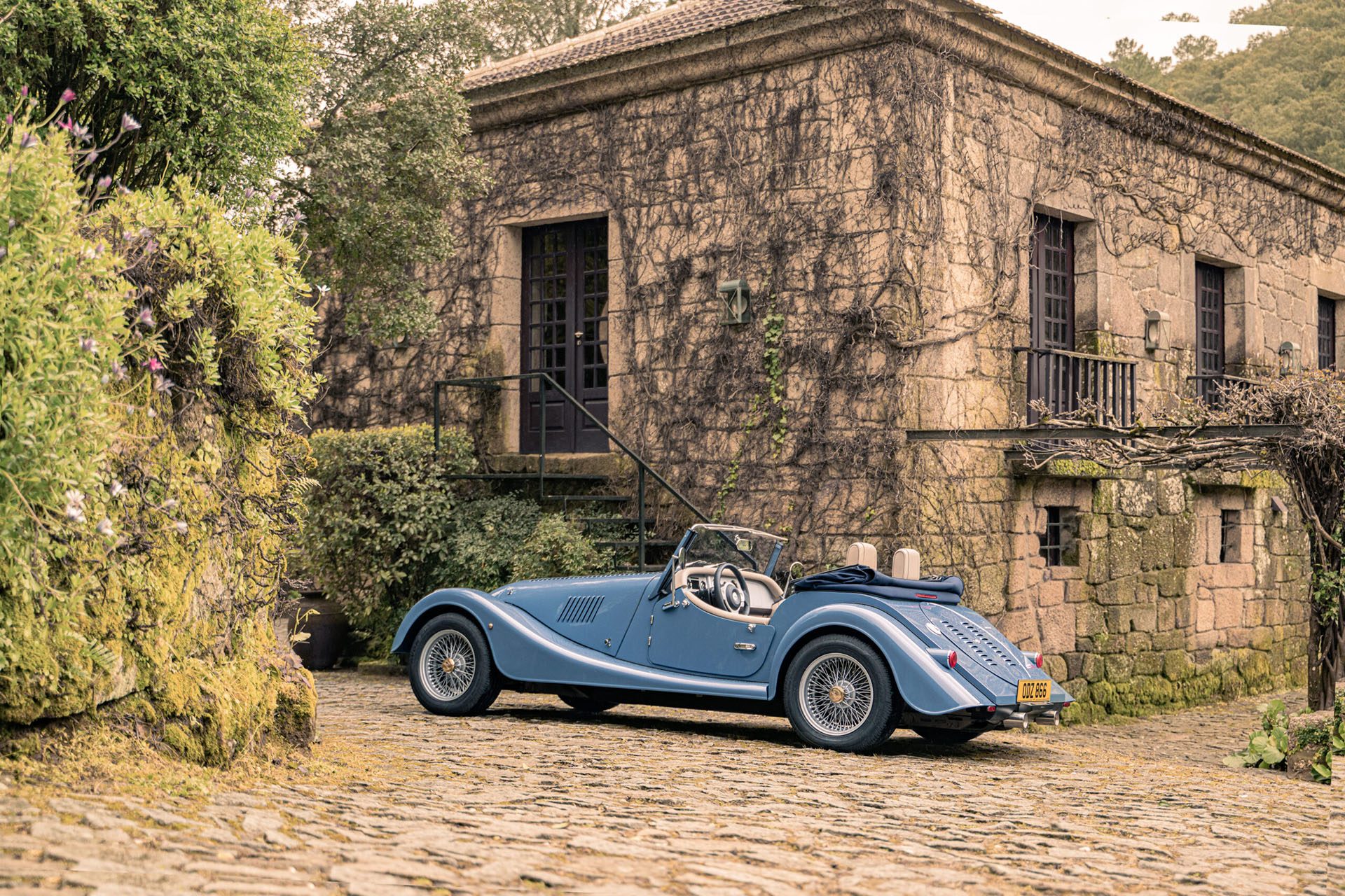 Old style car outside old style house.