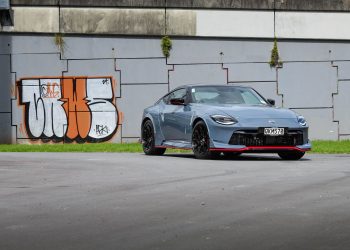 Nissan Z Nismo 400z, shown from the front quarter in front of graffiti'd wall