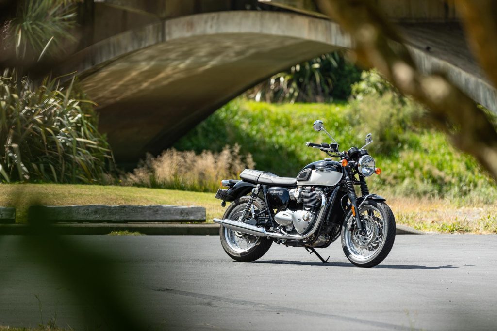 Triumph Bonneville T120, shown from front quarter angle, parked next to a bridge