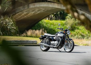 Triumph Bonneville T120, shown from front quarter angle, parked next to a bridge