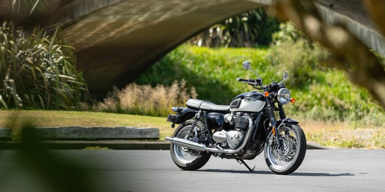 Triumph Bonneville T120, shown from front quarter angle, parked next to a bridge