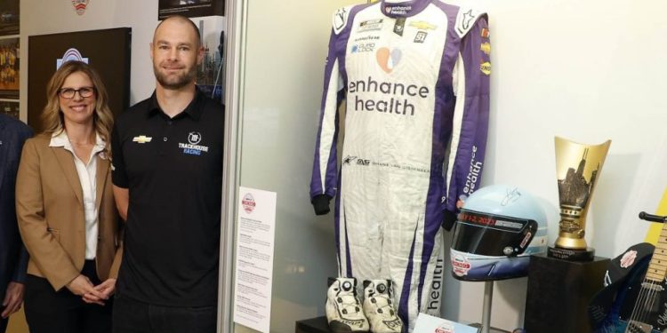 Shane van Gisbergen standing next to NASCAR Hall of Fame display
