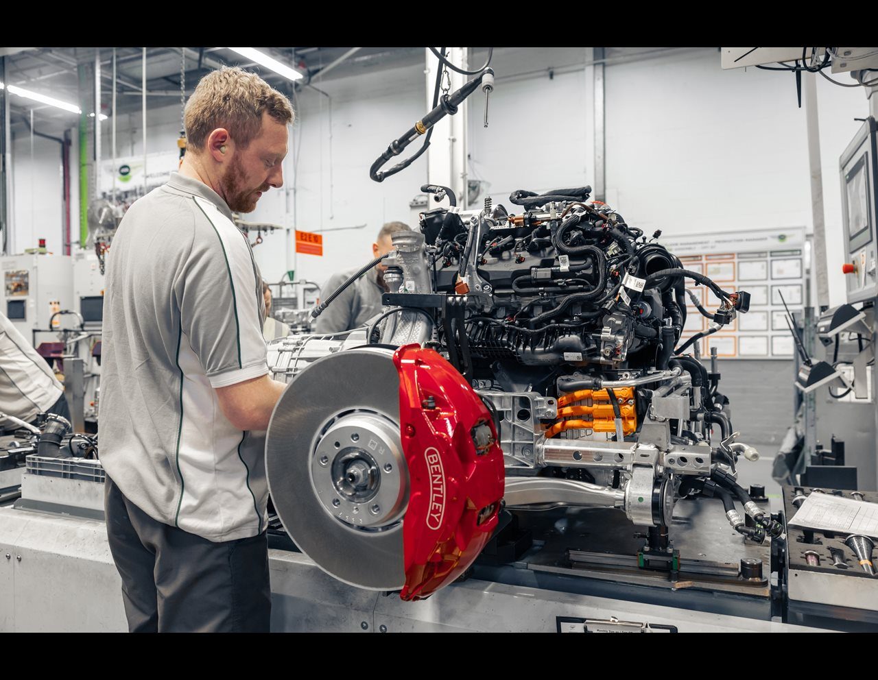 Guy busy doing stuff on Bentley's new hybrid powertrain.