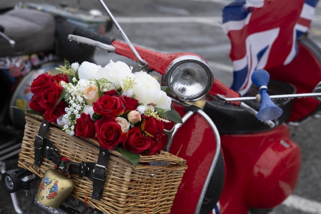 Roses adorn a rose-red Vespa.