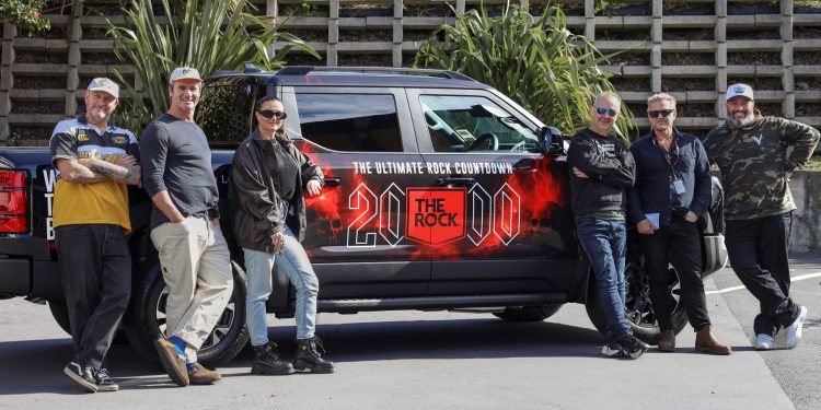 A BYD Shark with Rock livery and people standing next to it